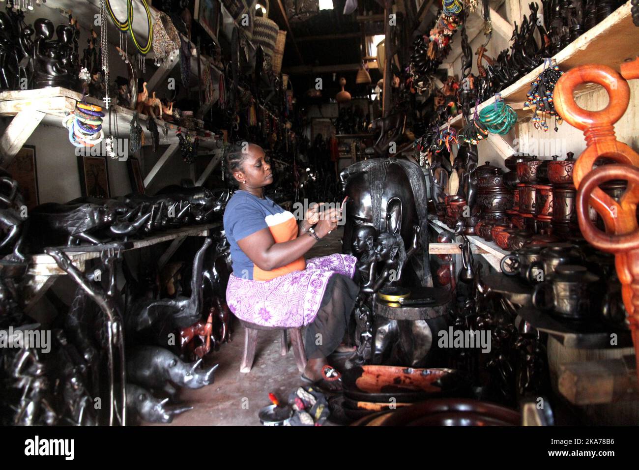 (200707) -- DAR ES SALAAM, July 7, 2020 (Xinhua) -- A shop owner polishes woodcarvings at her empty shop in Mwenge Woodcarvers Market in Dar es Salaam, Tanzania, July 6, 2020. Due to the outbreak of COVID-19, the city's artworks markets once popular among foreign tourists are nearly empty now. (Xinhua) Stock Photo