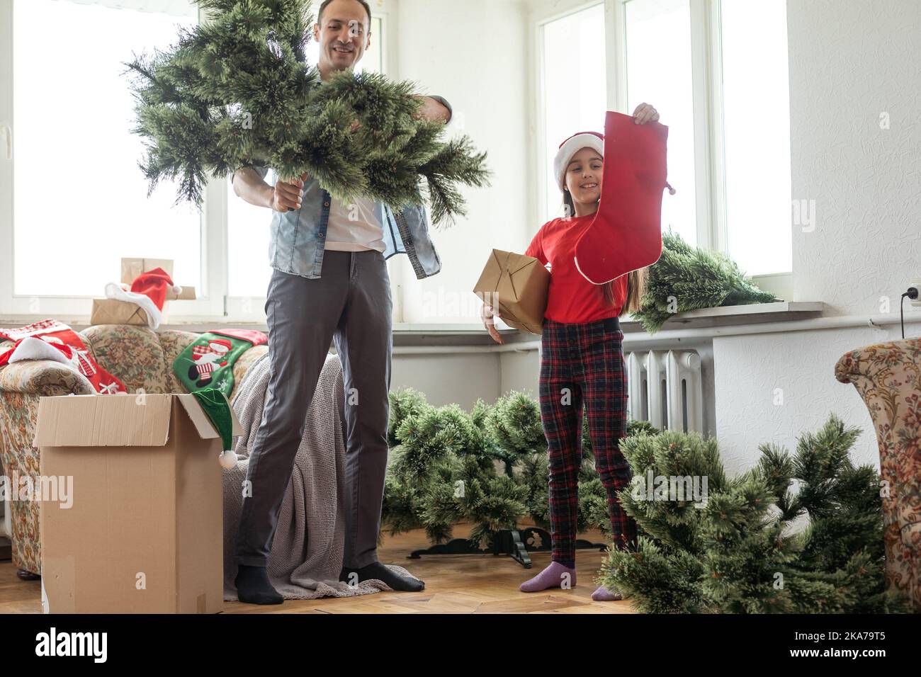 father and daughter install an artificial Christmas tree Stock Photo