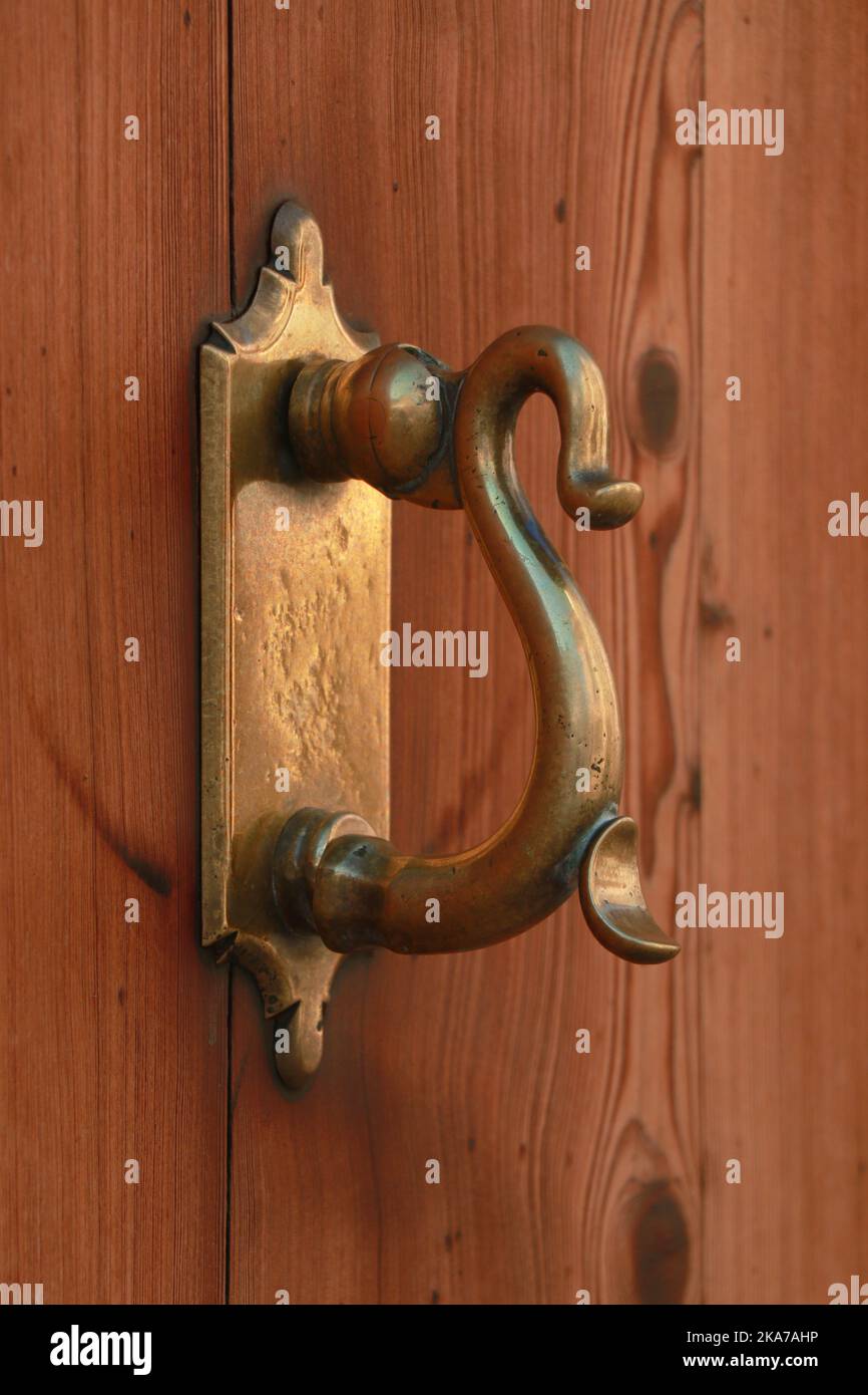Old Decorative Brass door knock on timber door  in Alcudia Mallorca Stock Photo