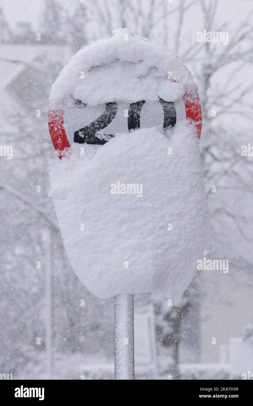 20 mph road sign partially obscured by snow - Scotland, UK Stock Photo