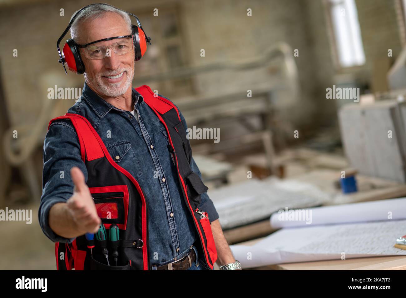 Smiling craft person stretching and greeting someone Stock Photo