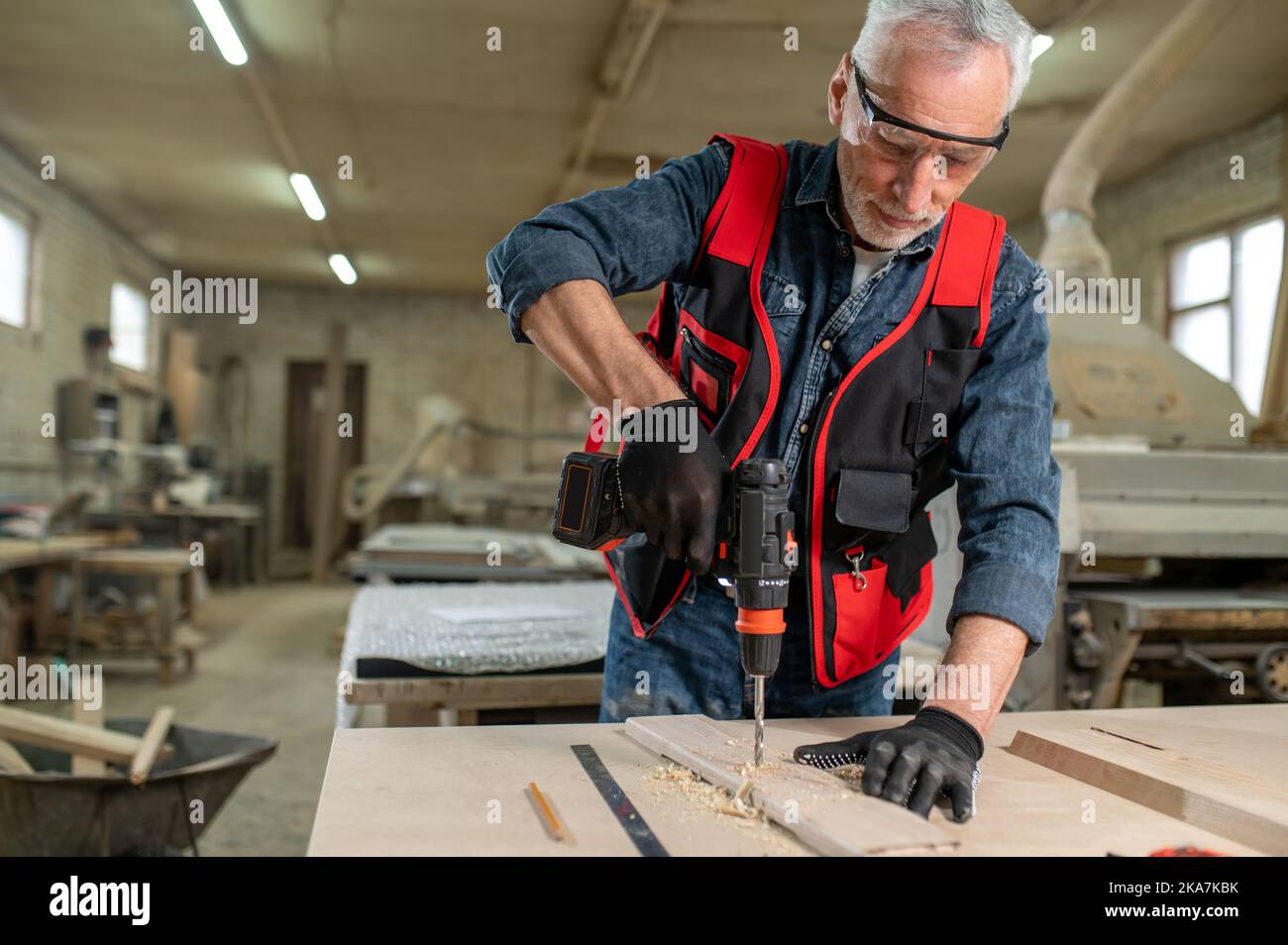 Craft person drlling wood in the workshop Stock Photo