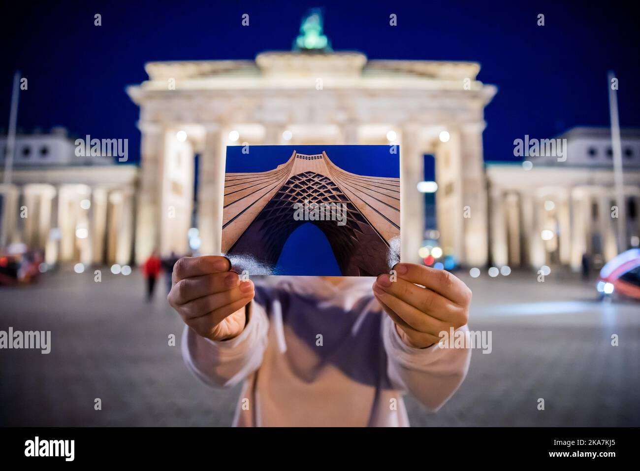 Berlin, Germany. 27th Oct, 2022. Asadeh (name changed) holds a postcard  with an image of the Freedom Tower (Azadi) of Tehran into the camera in  front of the Brandenburg Gate. Despite censorship