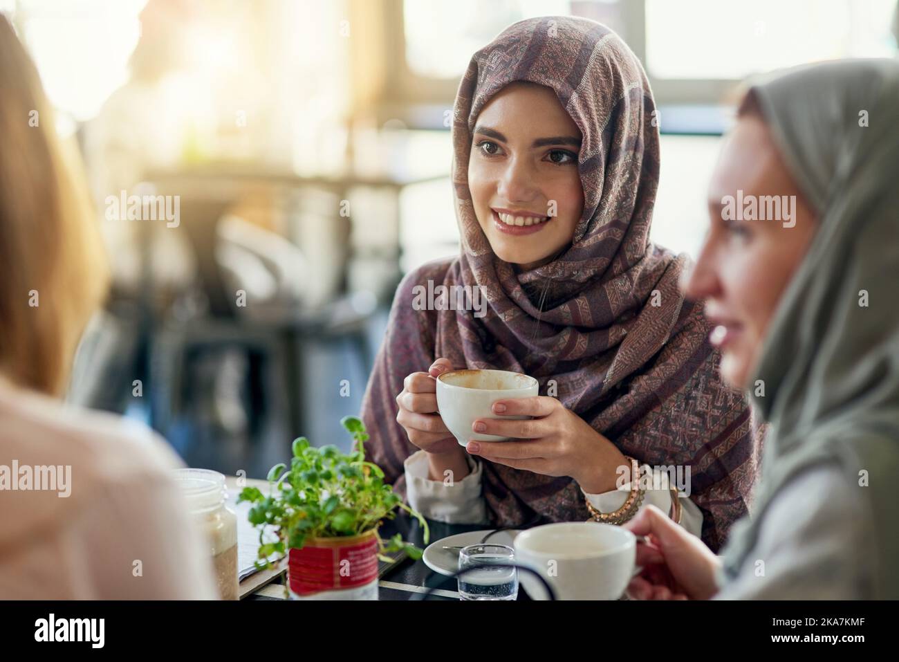Nothing brings people together like coffee. a group of women chatting over coffee in a cafe. Stock Photo