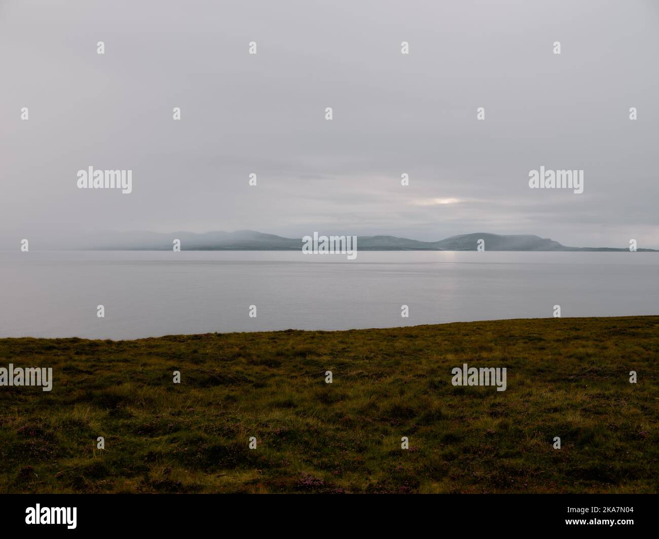 A distant view of the Isle of Skye and the dusk landscape of South Erradale near Gairloch on the west coast of Scotland UK Stock Photo