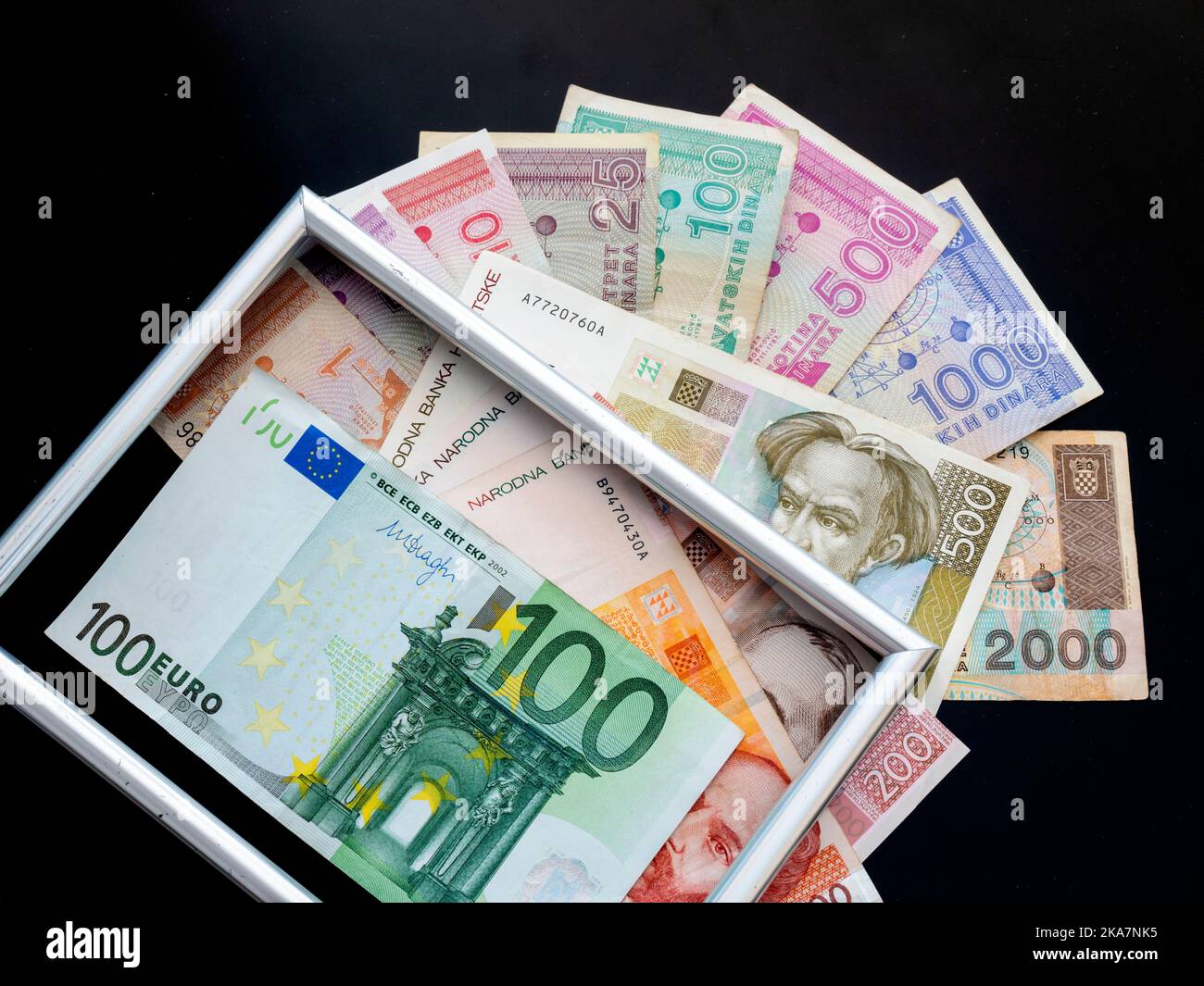 Framed picture frame atop Croat Croatia banknotes of Croatian Dinars Kuna Kune Kunas and EU Euro Euros on Black background Stock Photo