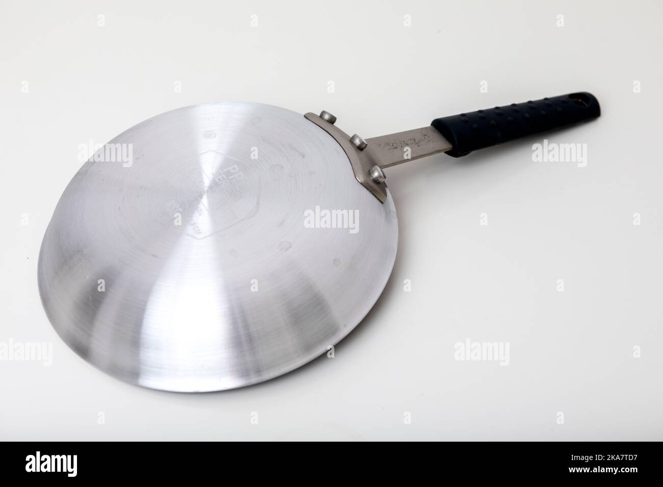 A stainless steel non-stick frying pan shot against a plain white background. Stock Photo