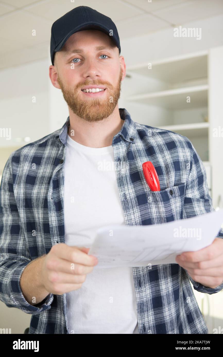 young engineer working on construction site and holding a blueprint Stock Photo