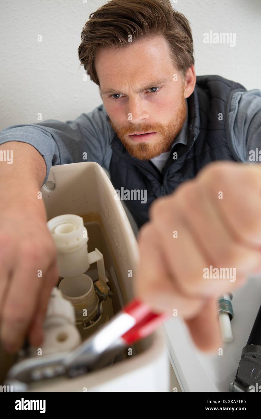 plumber repairing toilet cistern with pliers Stock Photo Alamy