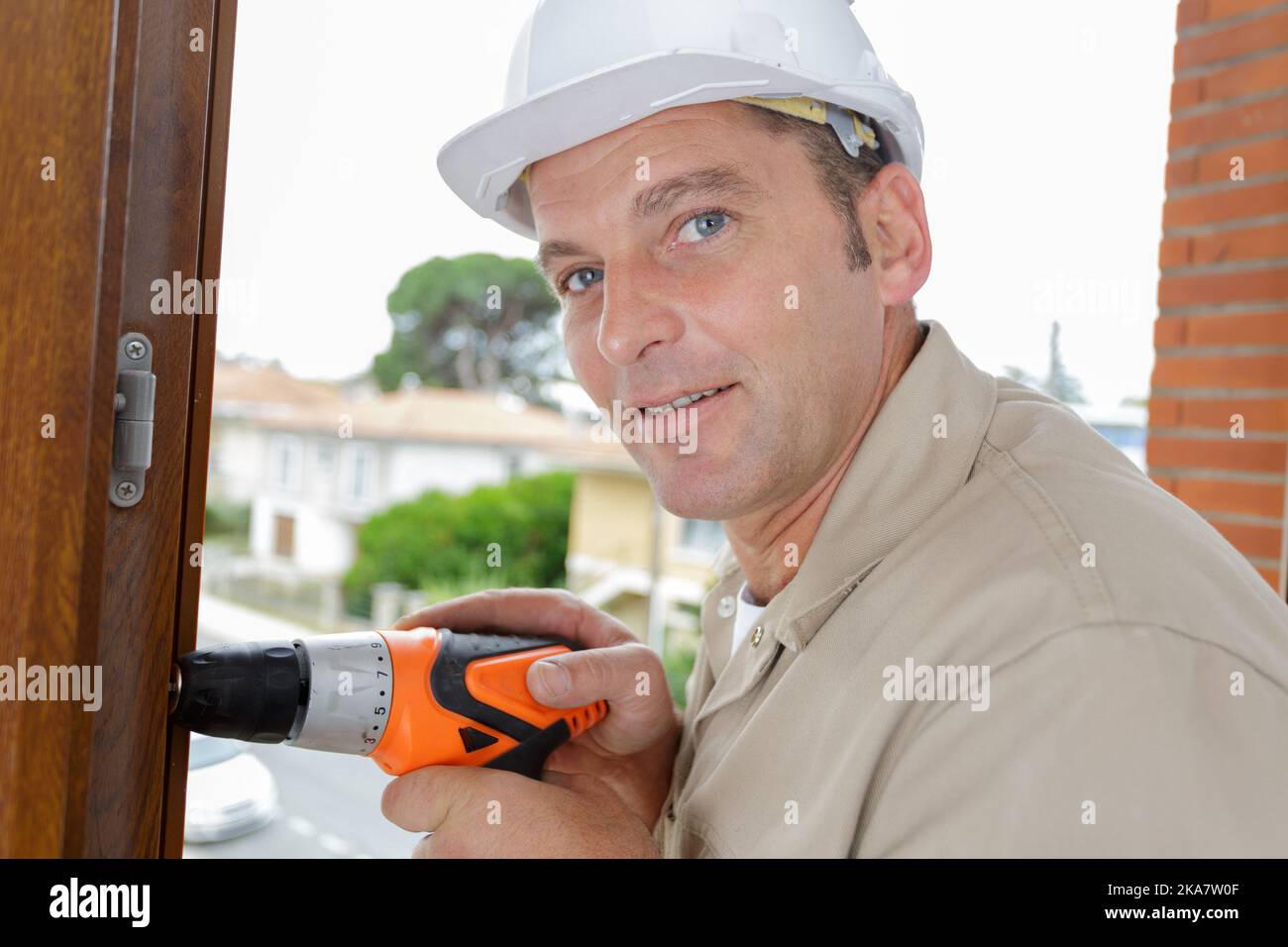 mature male builder using cordless drill Stock Photo