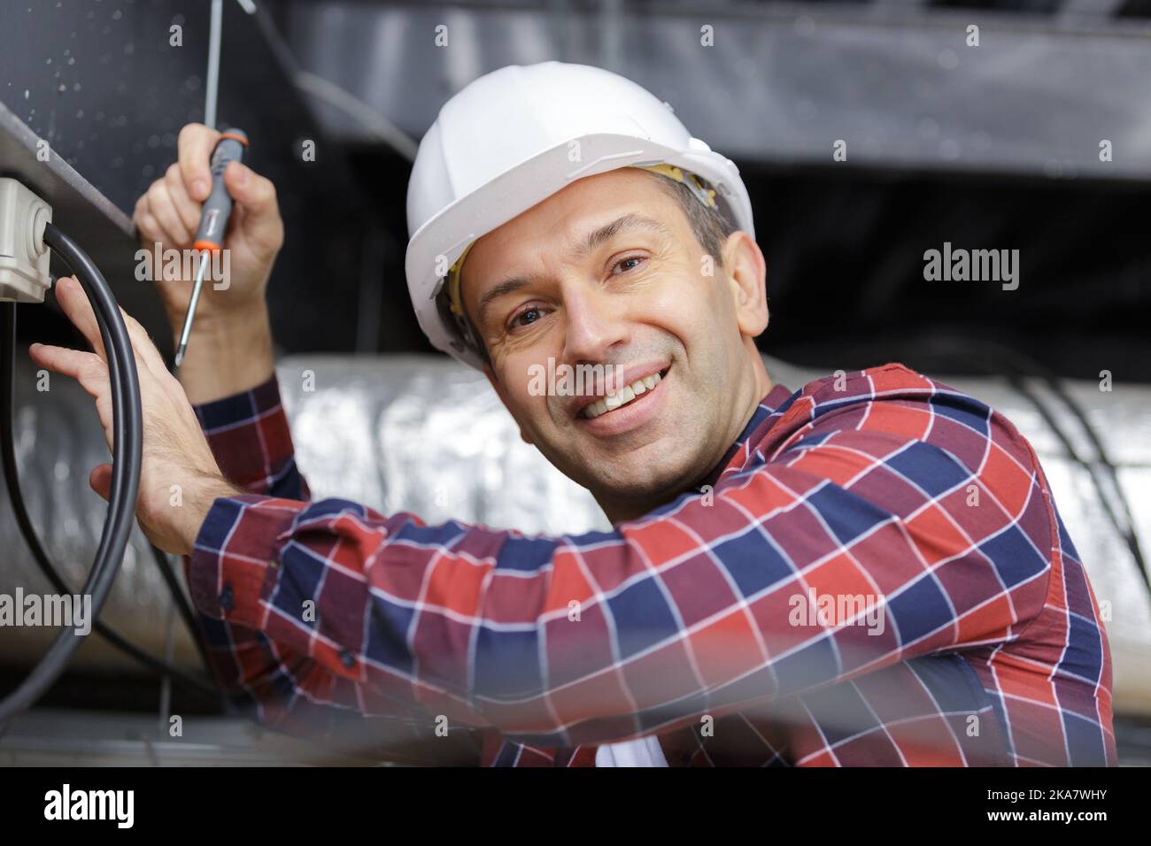 builder threading cables through wall Stock Photo Alamy