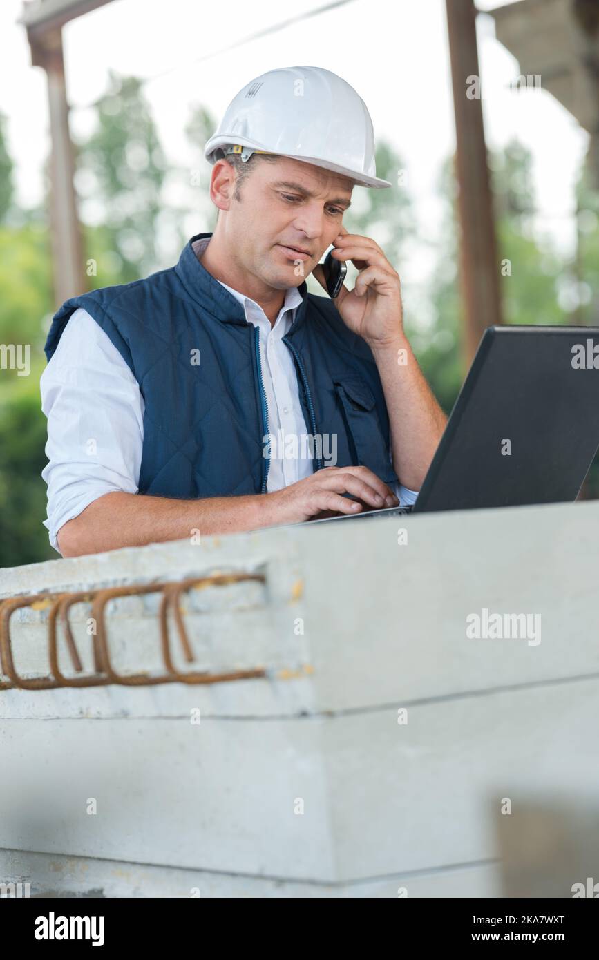 foreman looking at aptop on construction site Stock Photo