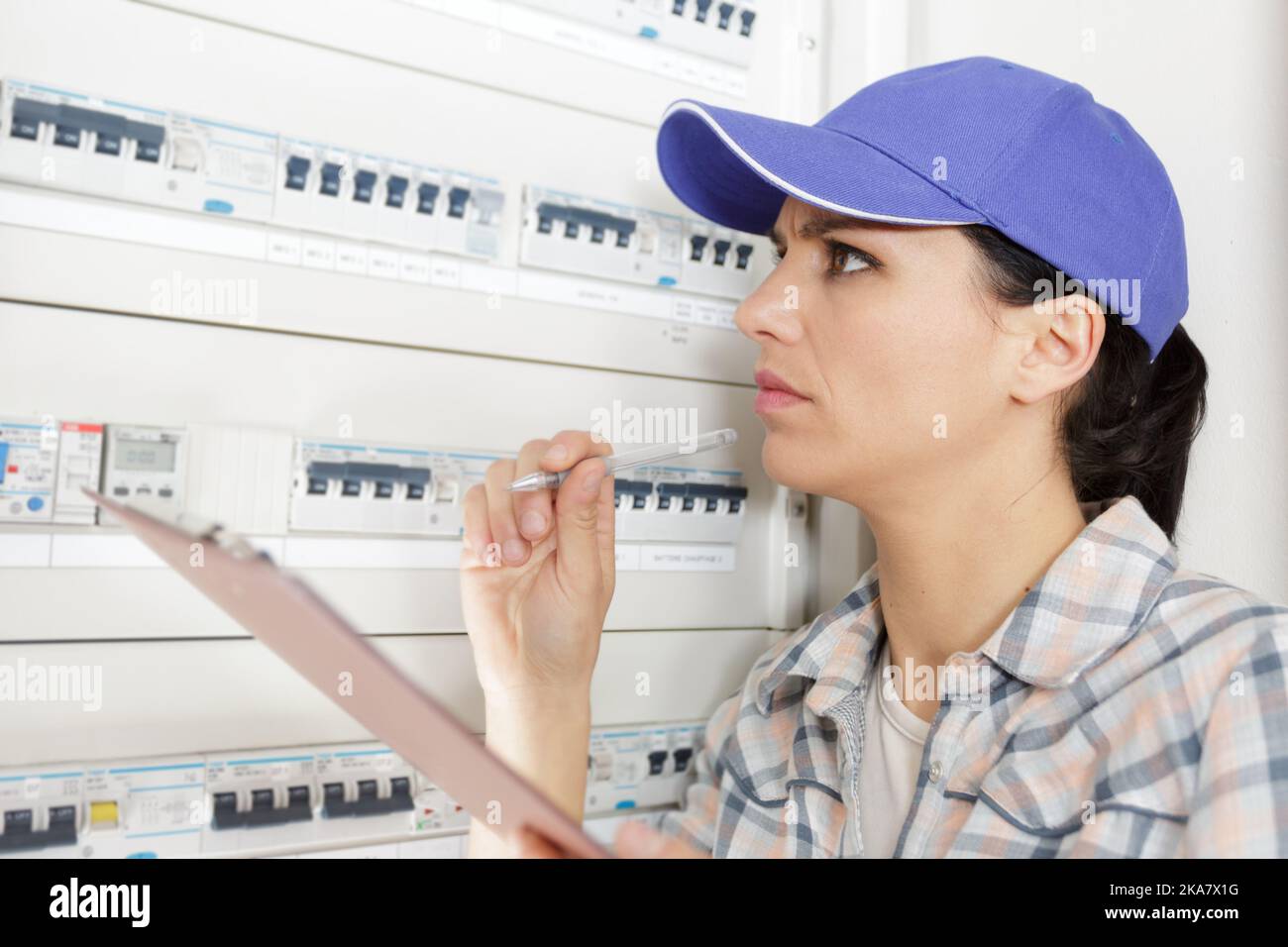 a lady inspecting a fuse board Stock Photo