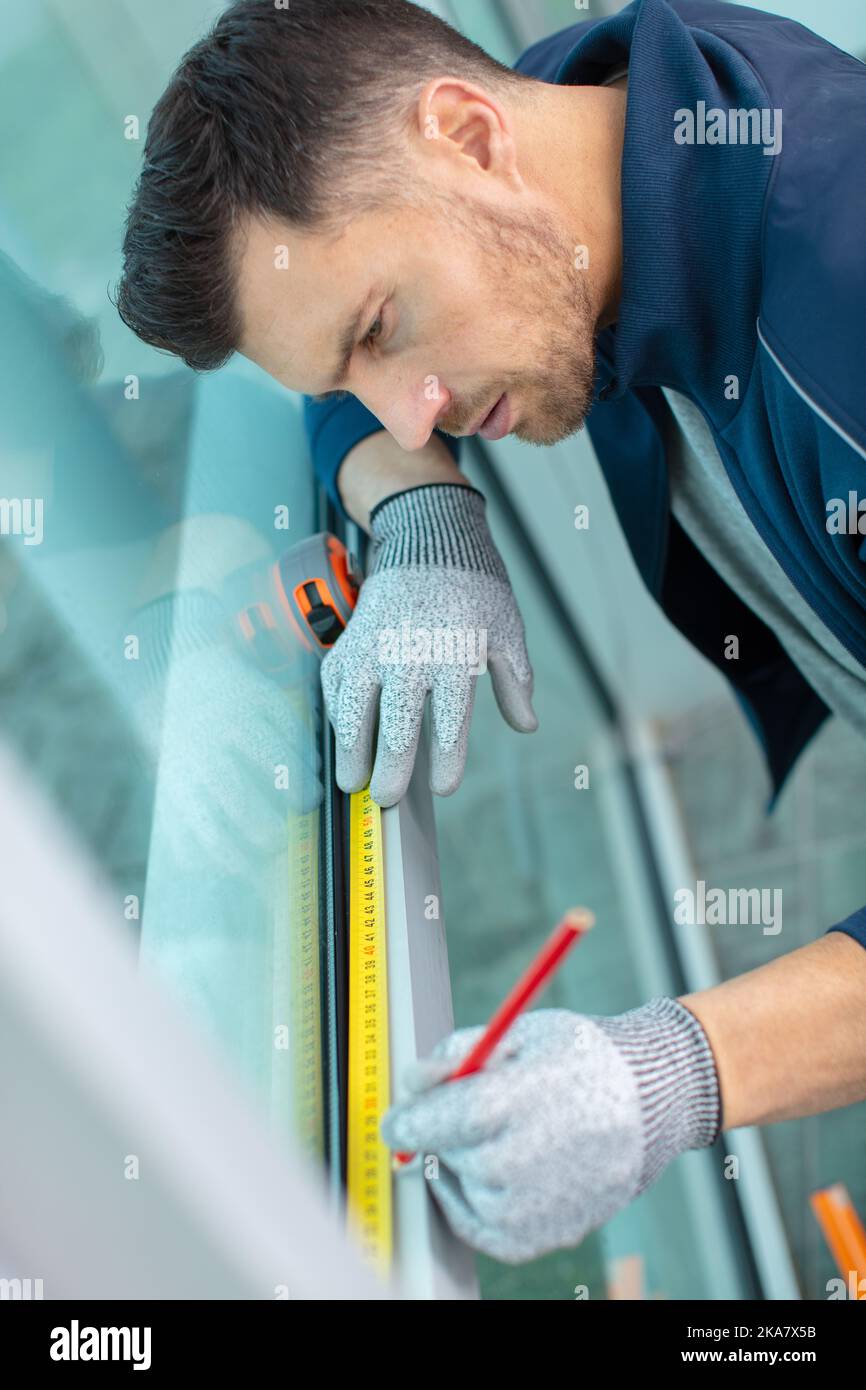 man installing cassette roller blinds on windows Stock Photo