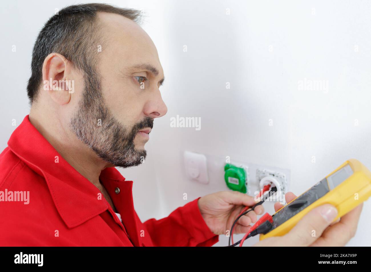 an electrician checking socket voltage Stock Photo Alamy