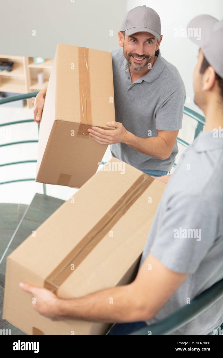 two mover wearing uniforms are unloading Stock Photo