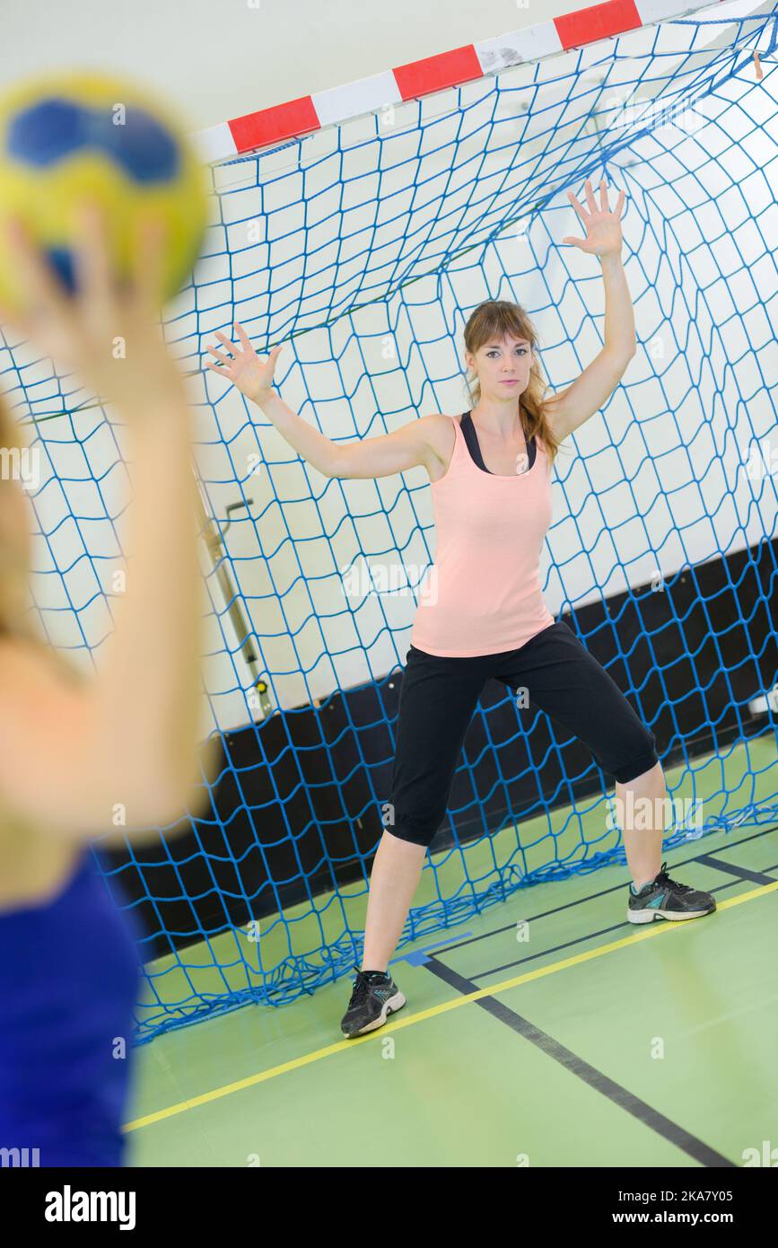 Woman defending goal in handball Stock Photo
