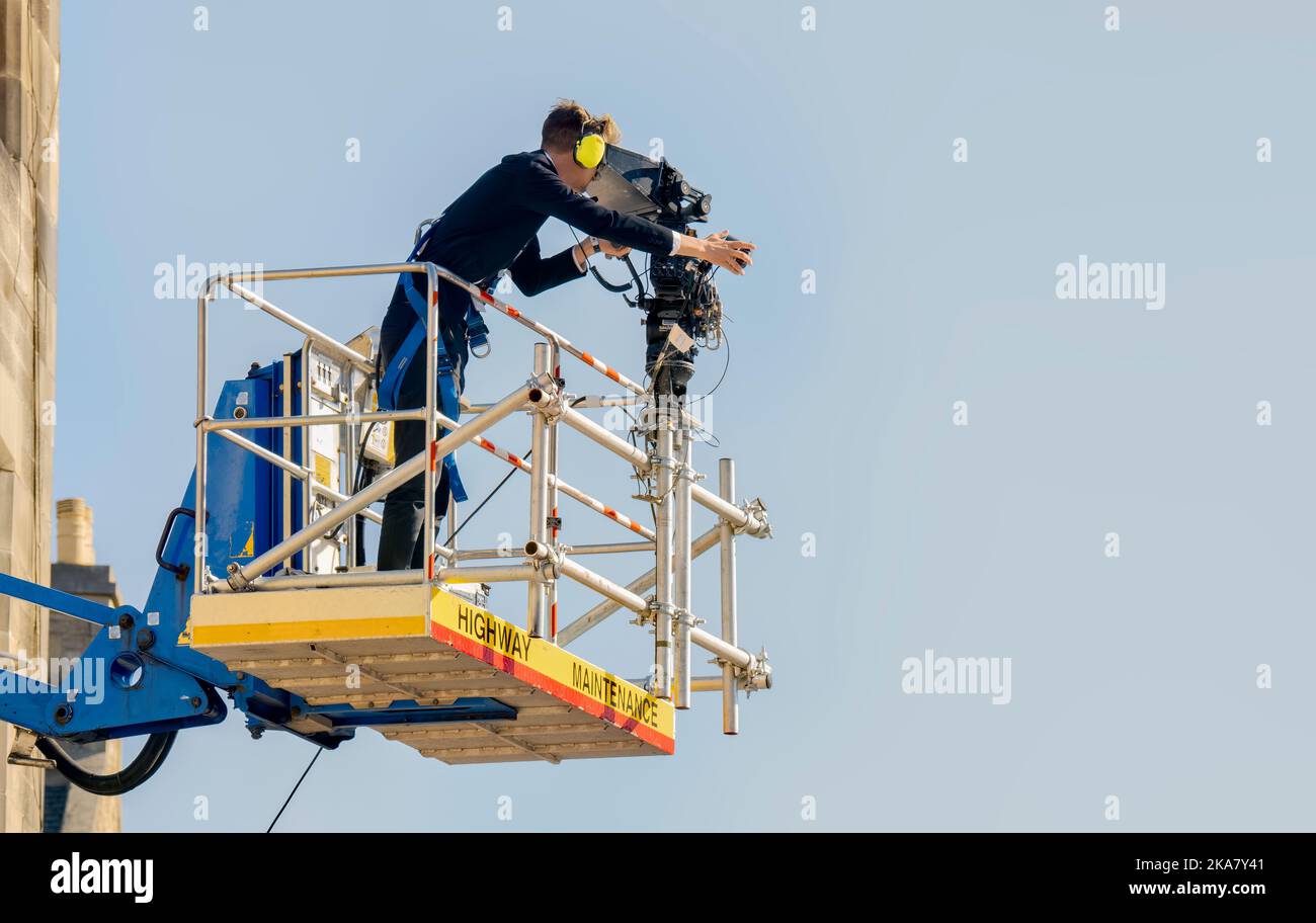 Television Cameraman on a Cherry Picker Crane filming at St Giles Cathedral, Edinburgh Stock Photo