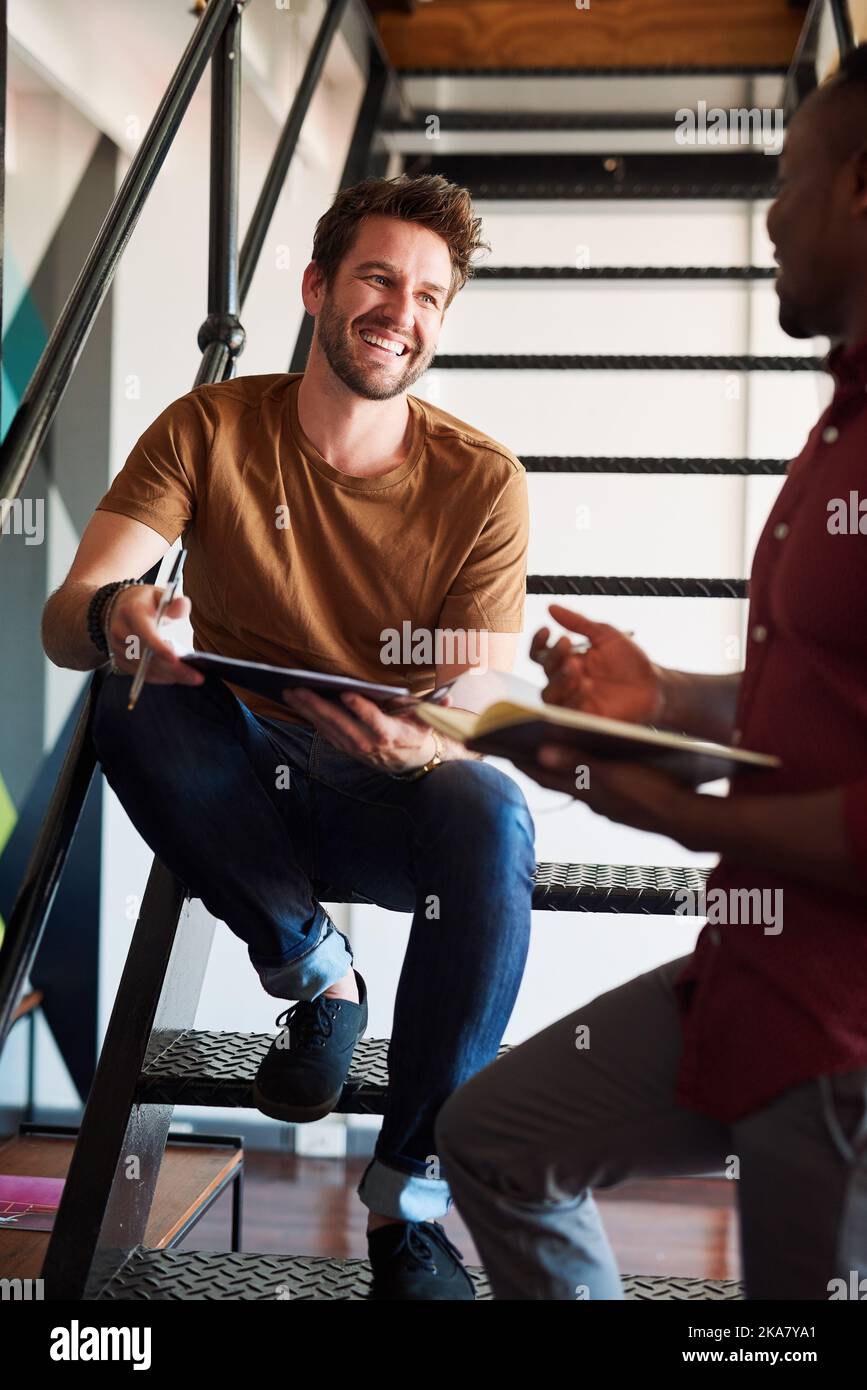 Advice is always welcome. two designers discussing something in an office. Stock Photo