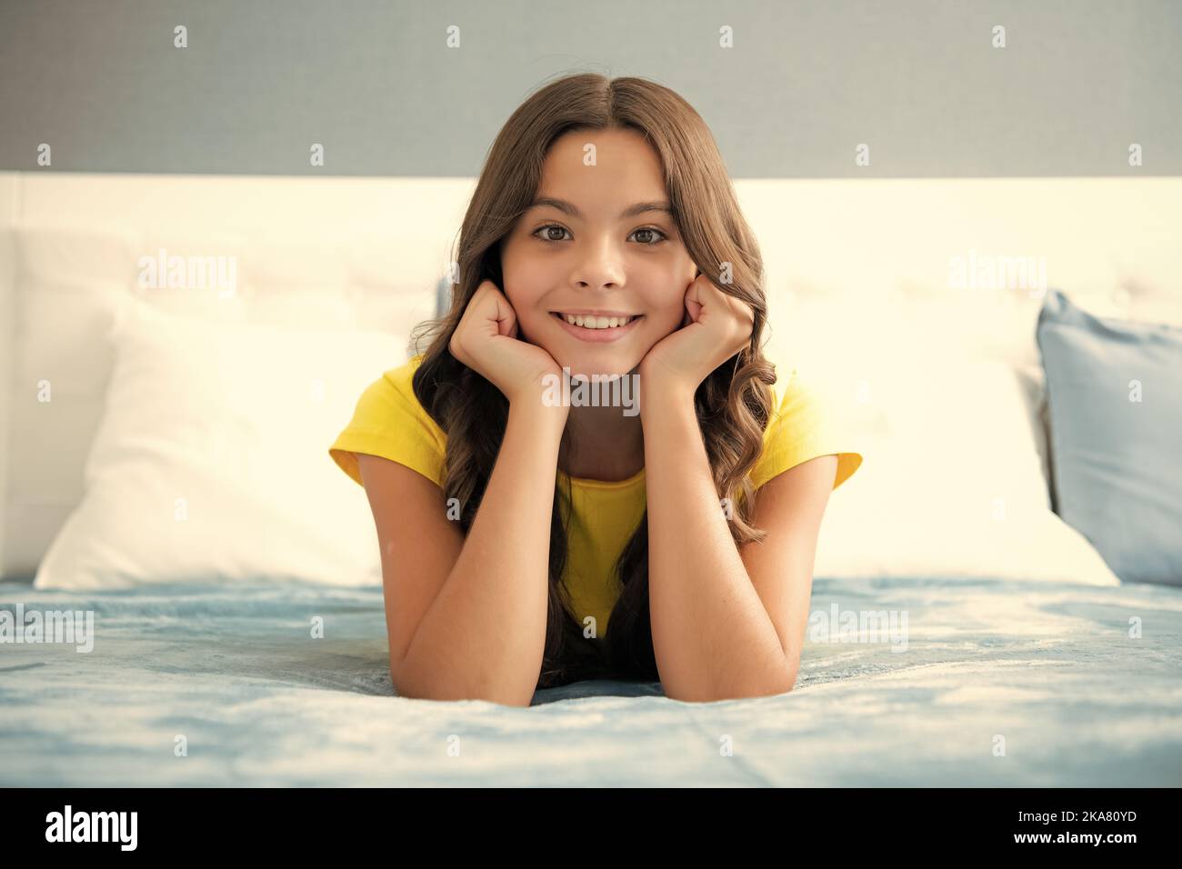 Teenager child girl resting in bed at home bedroom. Kid relaxing in