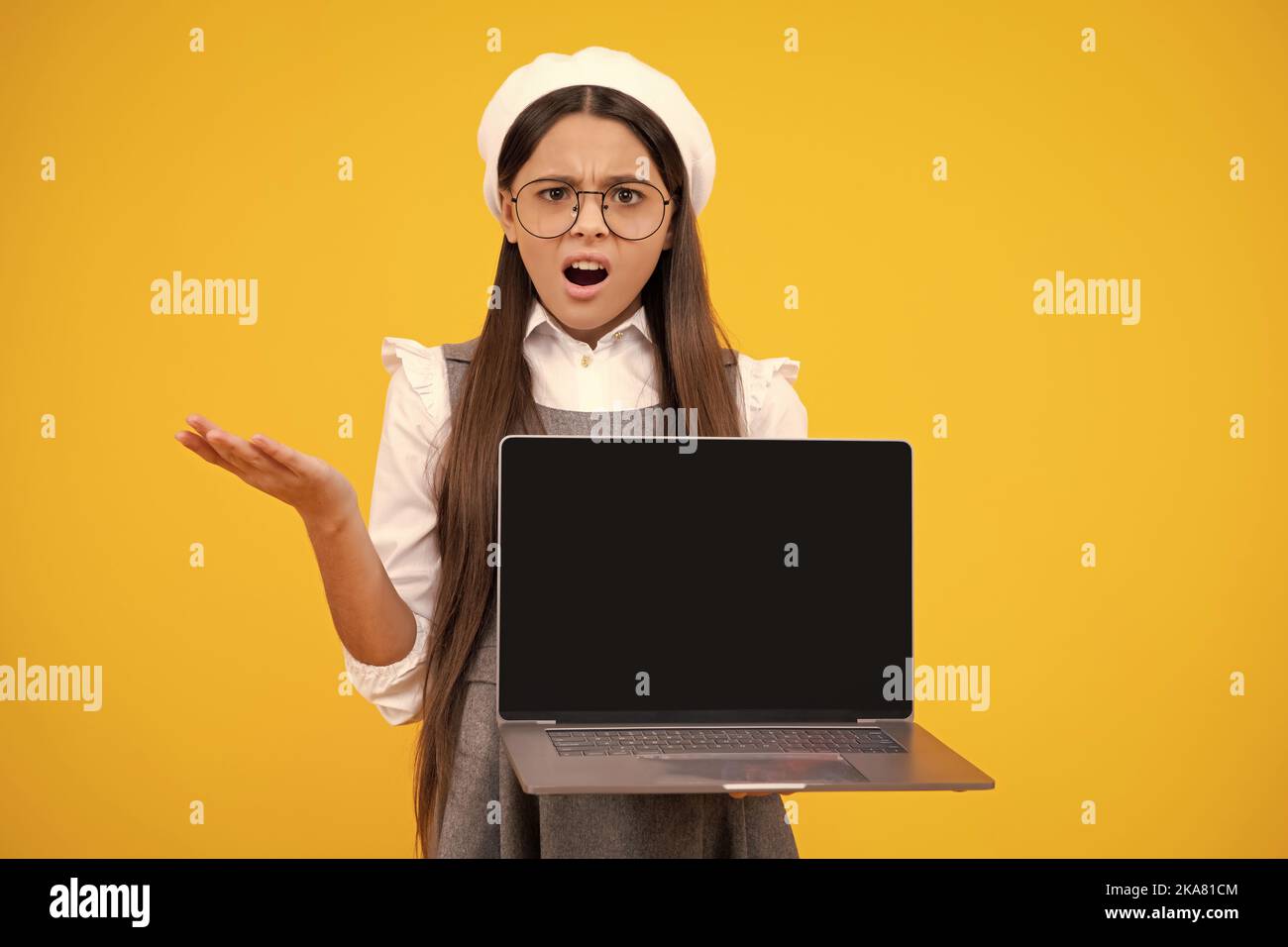 Student school girl with laptop on isolated studio background. Video online webinar, learn on laptop, elearning lesson, pc computer call. Surprised Stock Photo