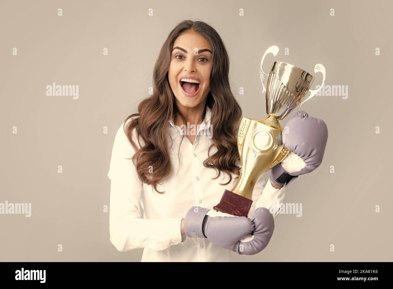 Woman in boxing gloves hold champion winner cup, trophy. Winning
