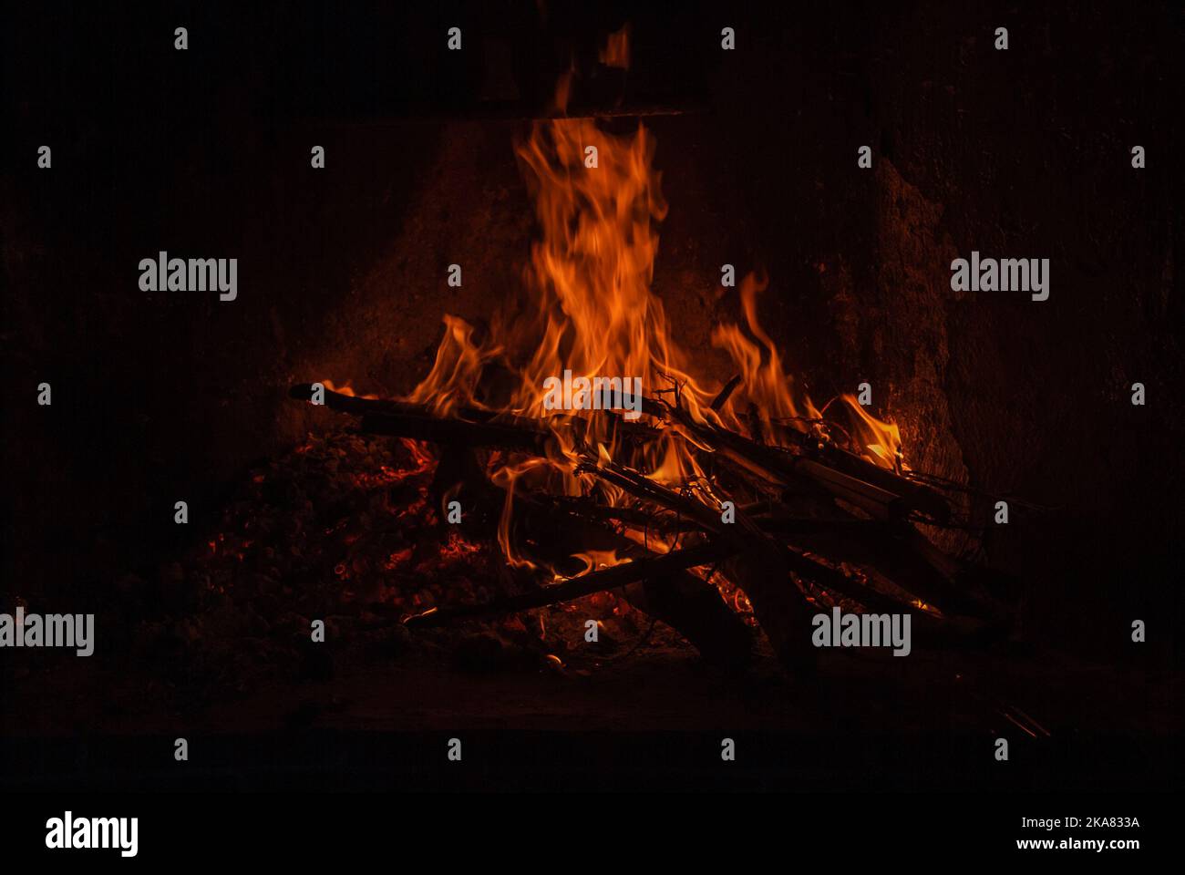 Firewood burning in corner of house, warmth of home and hypnotic image. Stock Photo