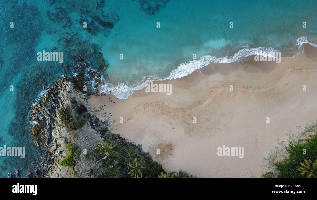 An aerial view of a scenic beach with turquoise water and white sand ...
