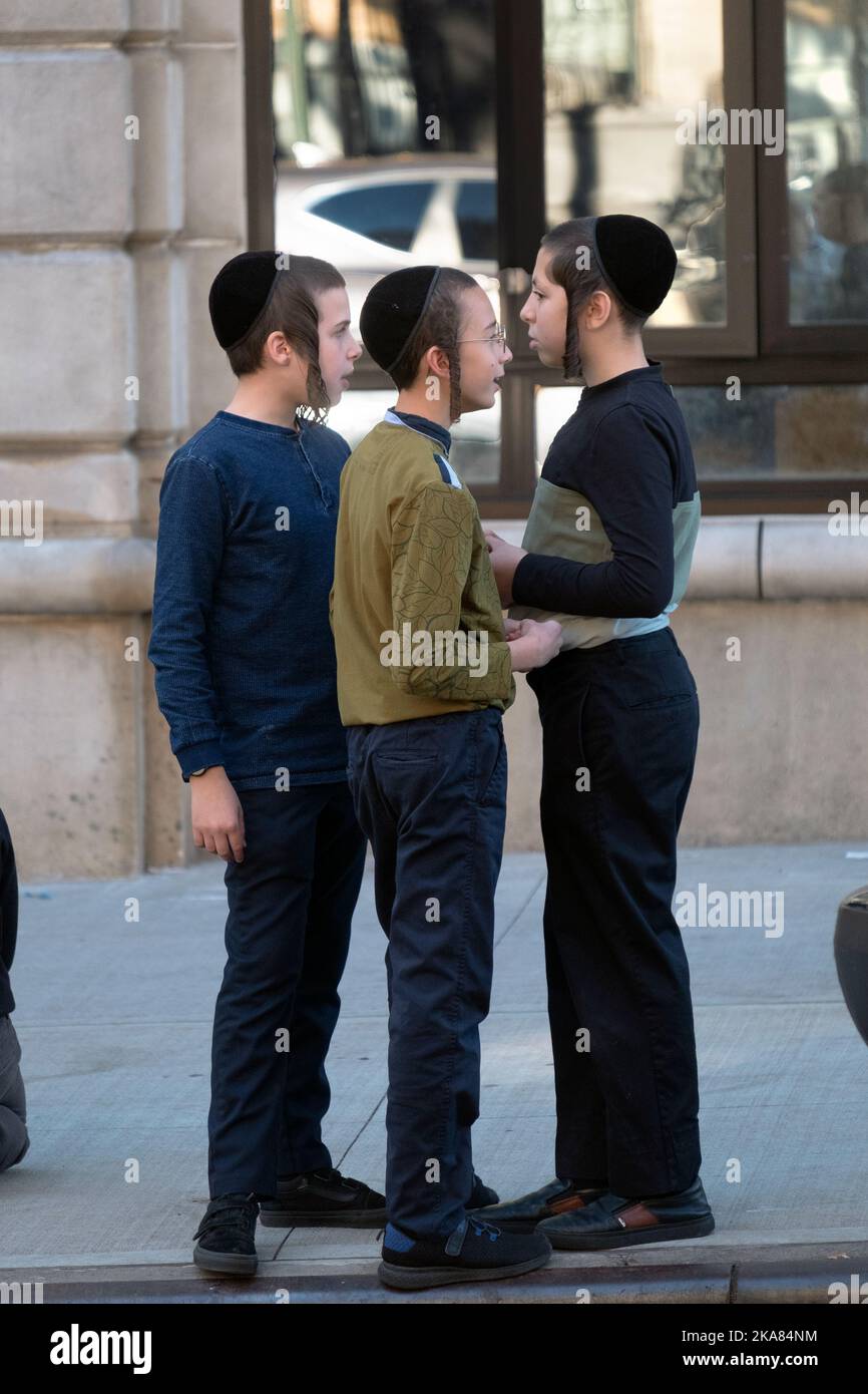 3 orthodox jewish boys from the Klausenberg Hasidic group hang out together during yeshiva school recess. In Brooklyn, New York Stock Photo