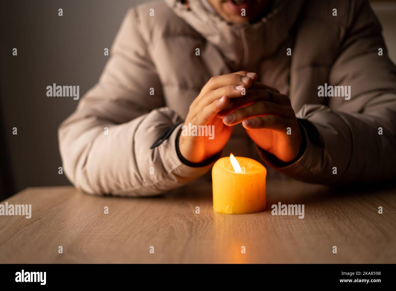 https://c8.alamy.com/comp/2KA859B/a-man-warms-his-hands-from-a-burning-candle-at-cold-house-close-up-shutdown-of-heating-and-electricity-power-outage-blackout-energy-crisis-2KA859B.jpg