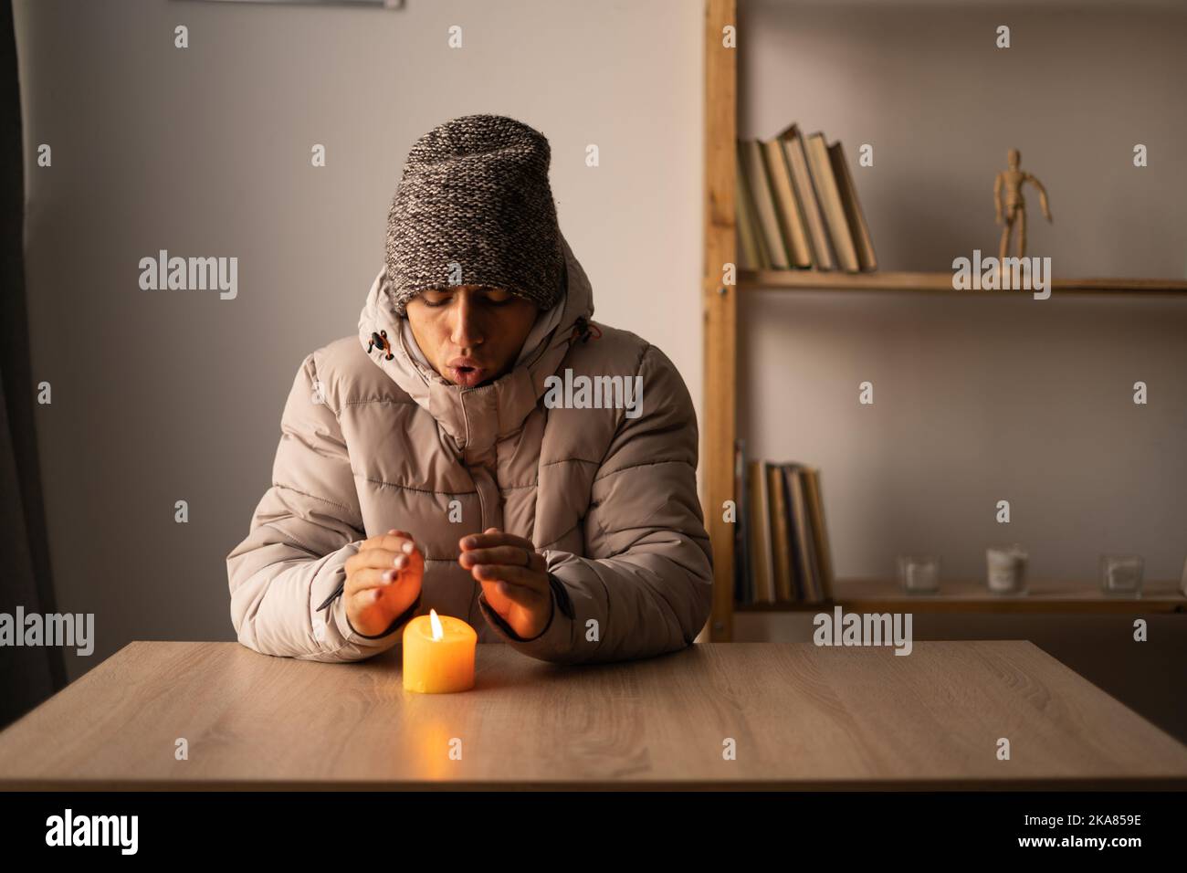 https://c8.alamy.com/comp/2KA859E/freezing-young-man-in-winter-clothes-warms-hands-on-burning-candle-shutdown-of-heating-and-electricity-power-outage-blackout-load-shedding-or-2KA859E.jpg