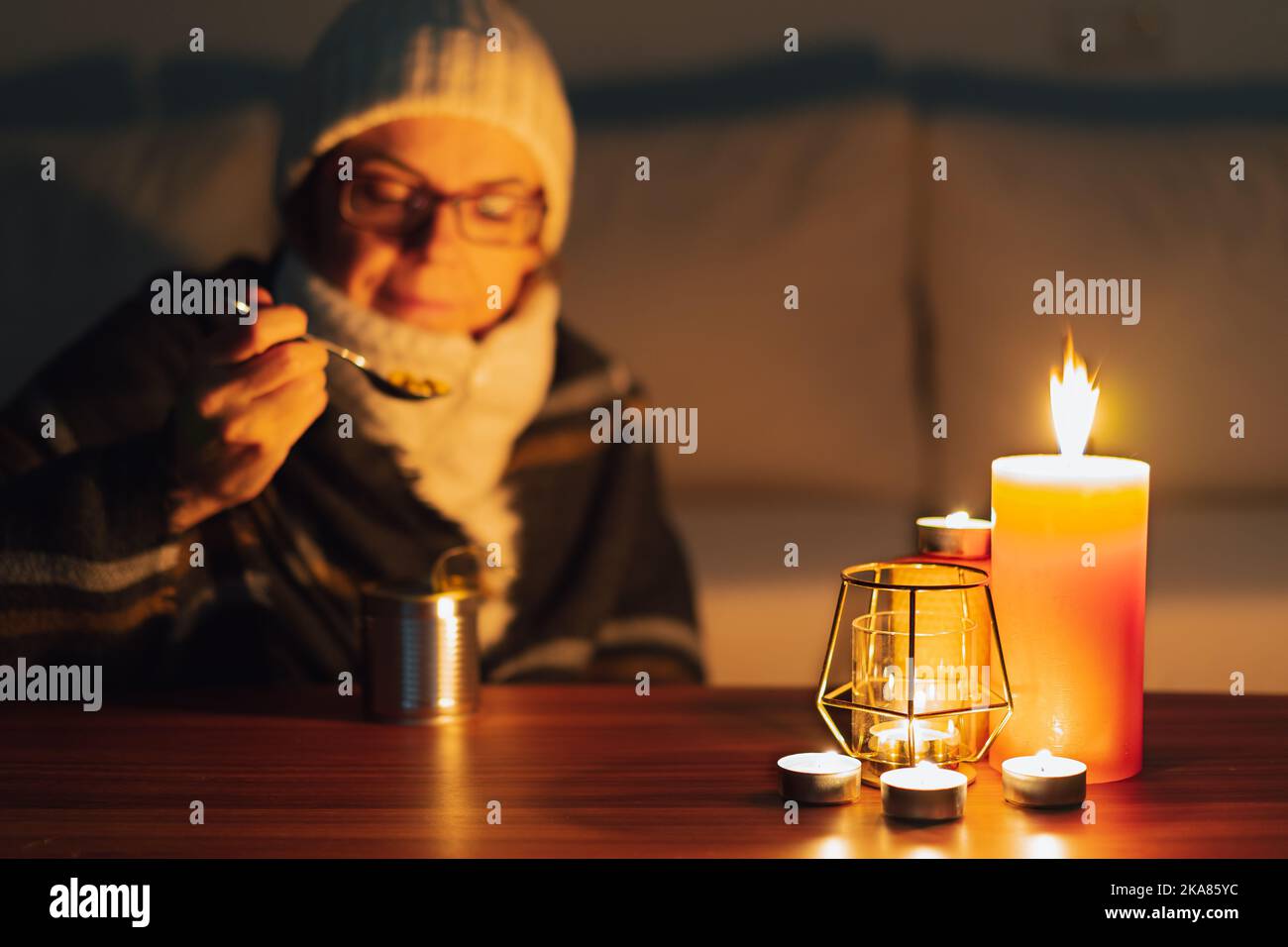 https://c8.alamy.com/comp/2KA85YC/woman-eating-canned-food-by-candlelight-electricity-and-gas-outages-in-winter-power-cut-2KA85YC.jpg