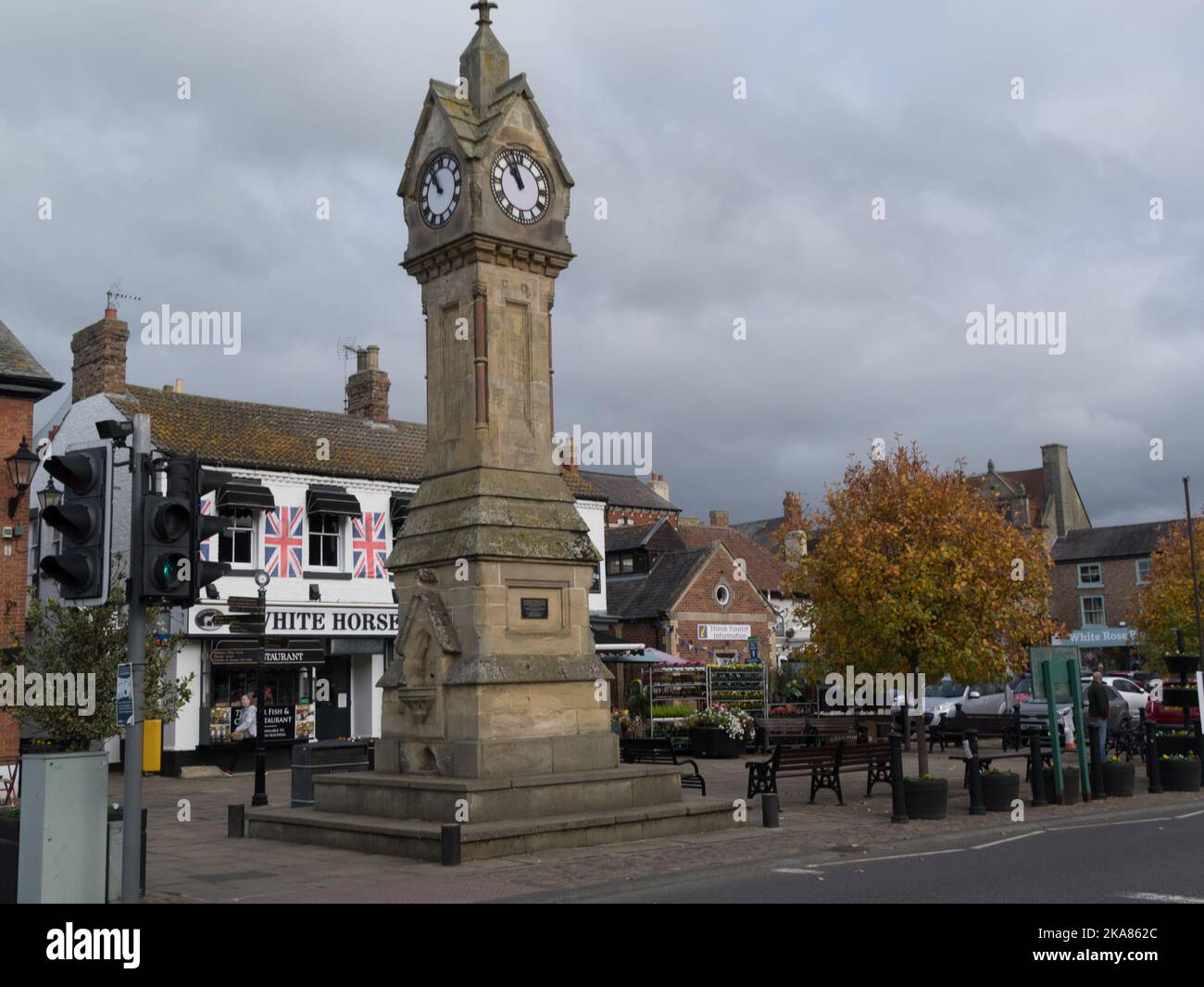 Clock Tower in centre of Thirsk town market place with White Horse restaurant behind North Yorkshire England UK Stock Photo
