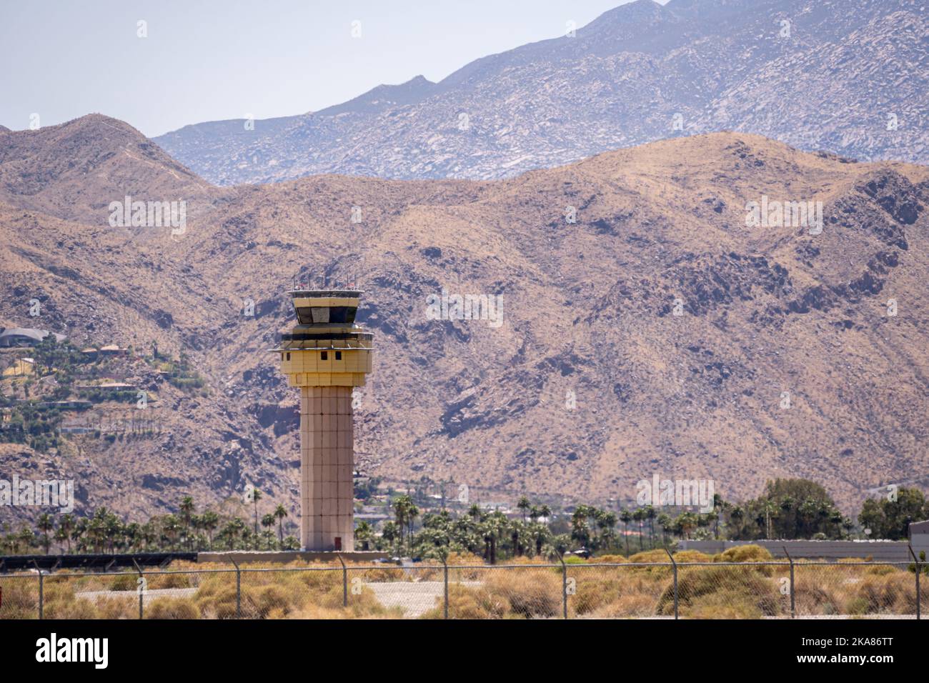 A scenic view of the airport control tower in Palm Strings, California surrounded by rocky hills on a hot day Stock Photo