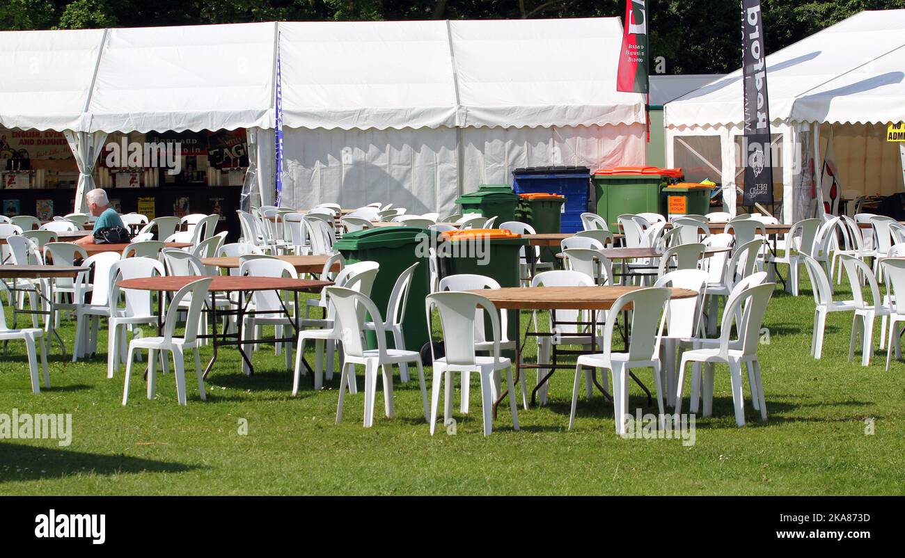 Tables and chairs outside by a marquee for public to dine at a summer ...