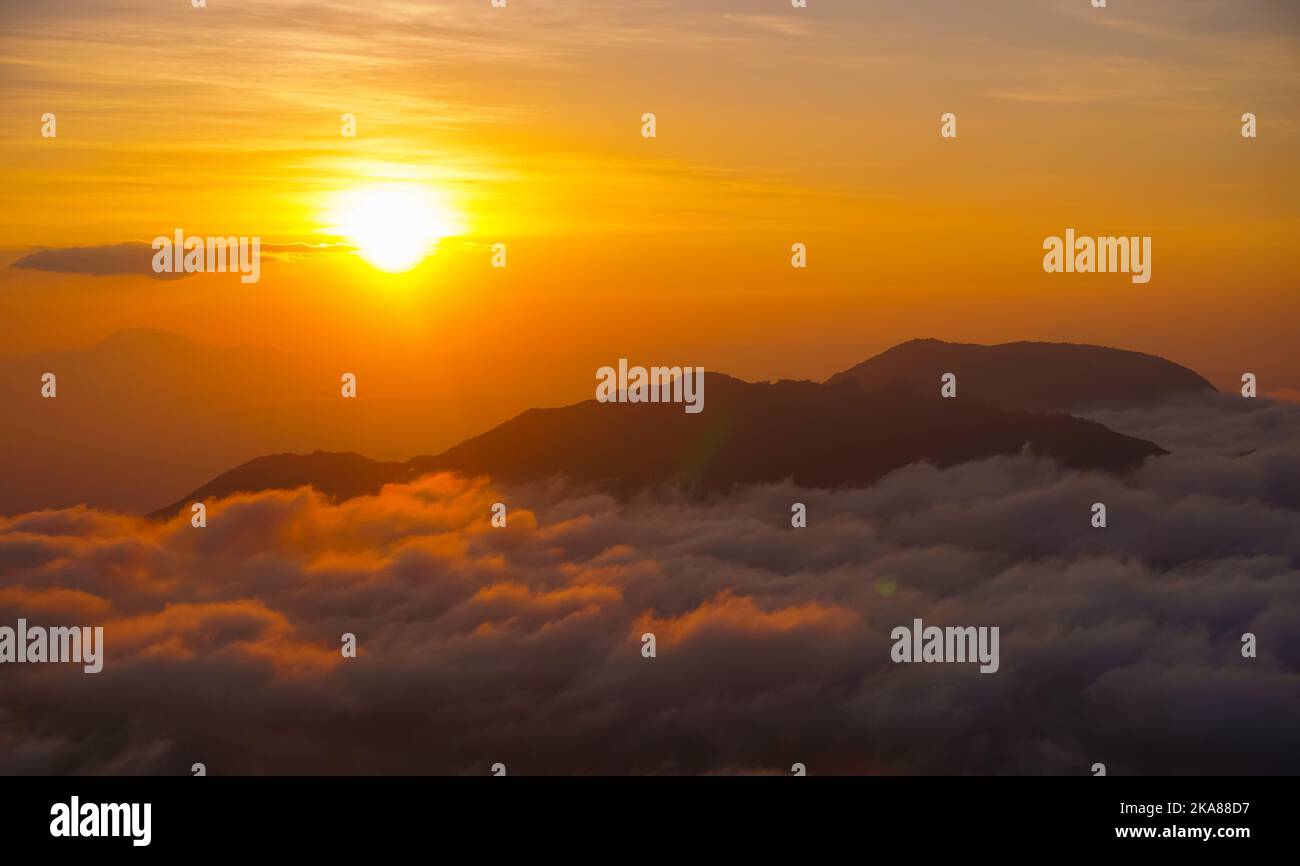 A golden sunrise mountain peak with a sea of clouds. Perfect for nature ...