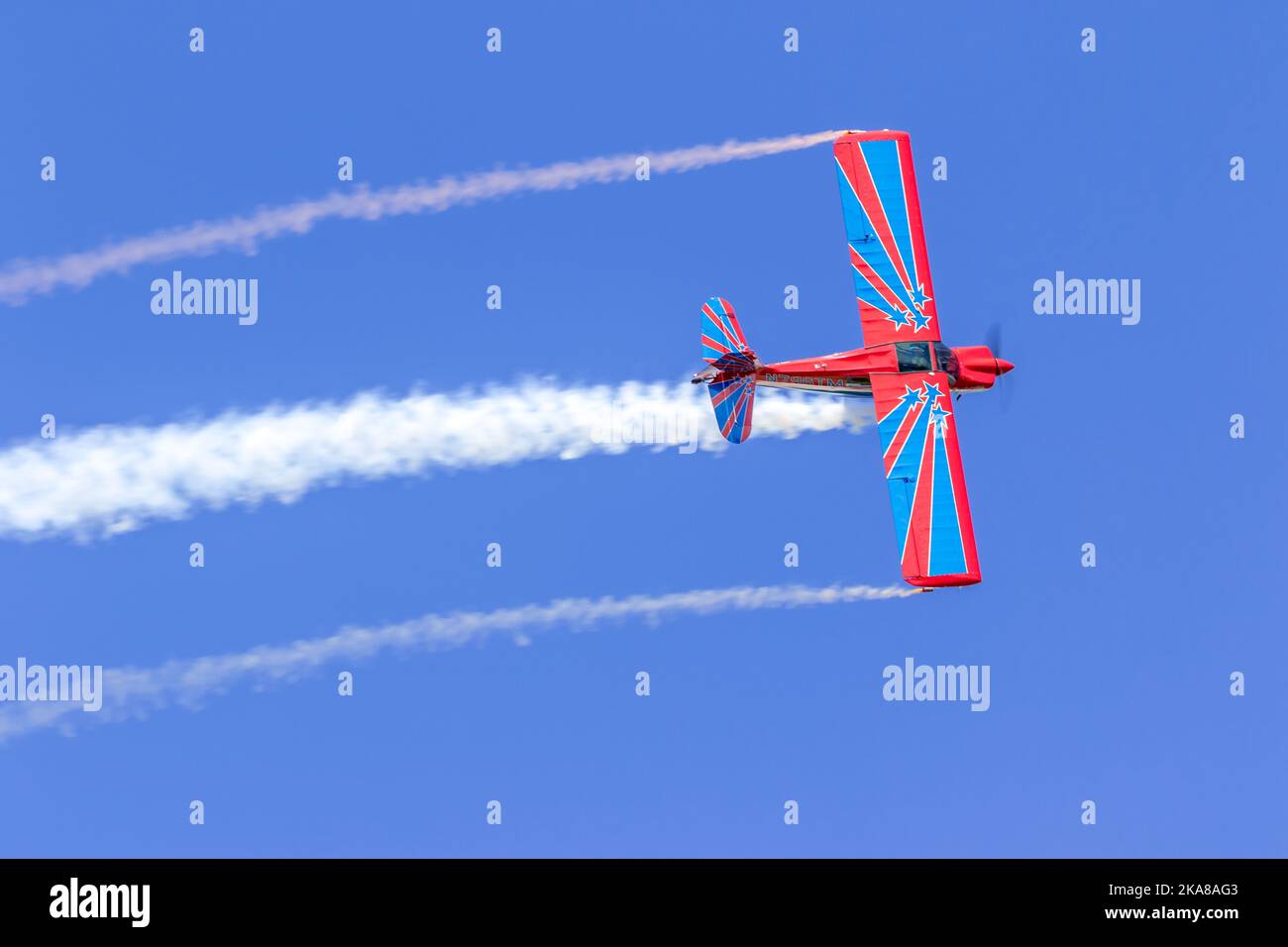 The red and blue plane flying in the blue sky at the air show. Orlando