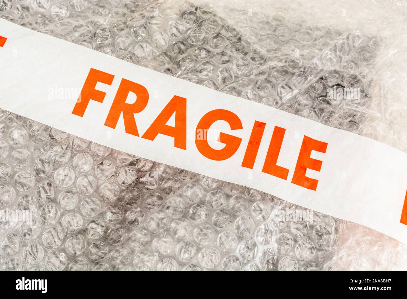 'Fragile' sticky tape labelling on plastic padded packing material or sheet containing the