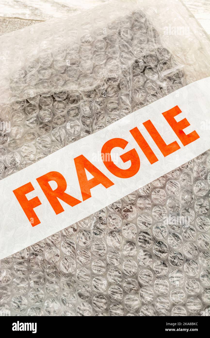 'Fragile' sticky tape labelling on plastic padded packing material or sheet containing the