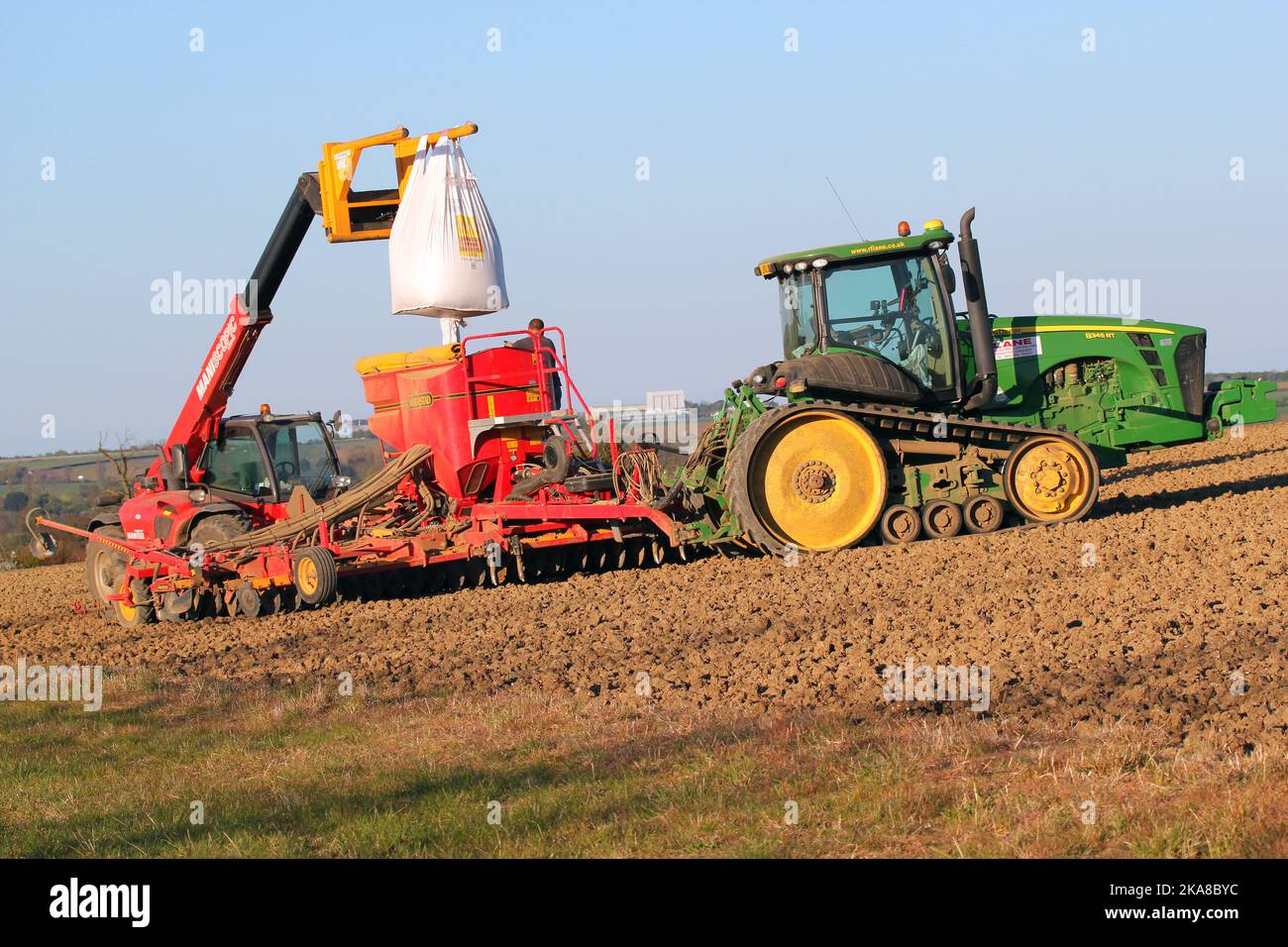 Loading crop seed into a hopper for tractor to sow. Growing crops. Stock Photo