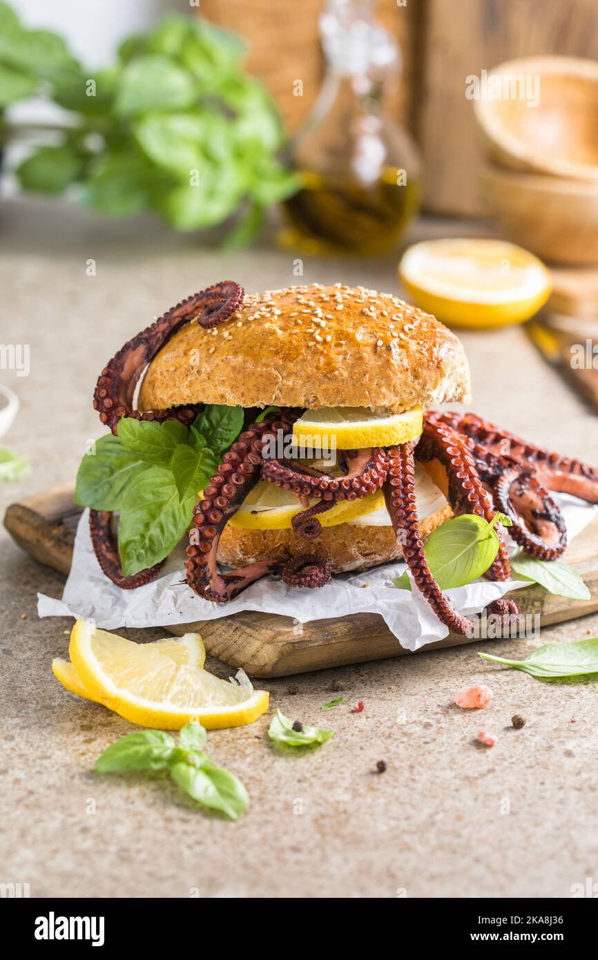 Big burger with octopus and lemon. Large sandwich stuffed with seafood