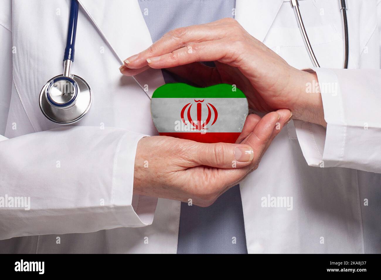 Iranian doctor holding heart with flag of Iran background. Healthcare