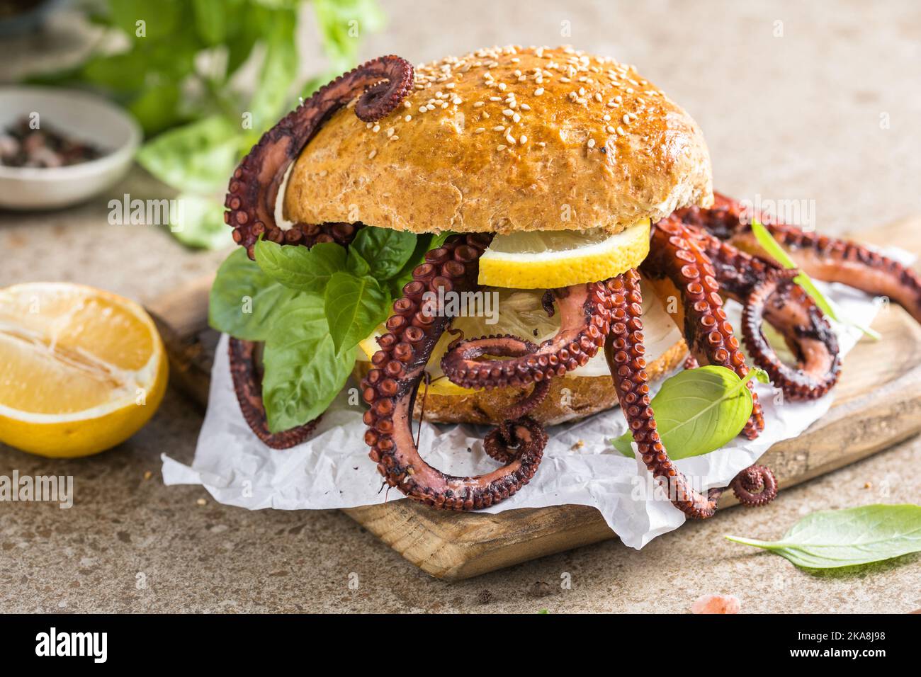 Big burger with octopus and lemon. Large sandwich stuffed with seafood