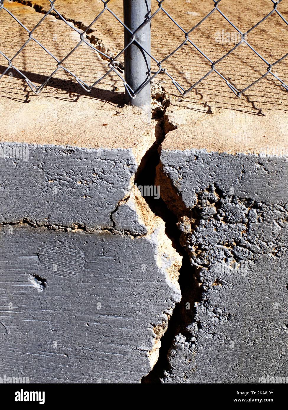 Chain link fence and pole on cracked cement wall texture Stock Photo