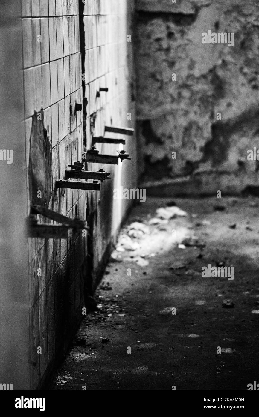 Interior of an old damaged bathroom with dirty walls. Stock Photo