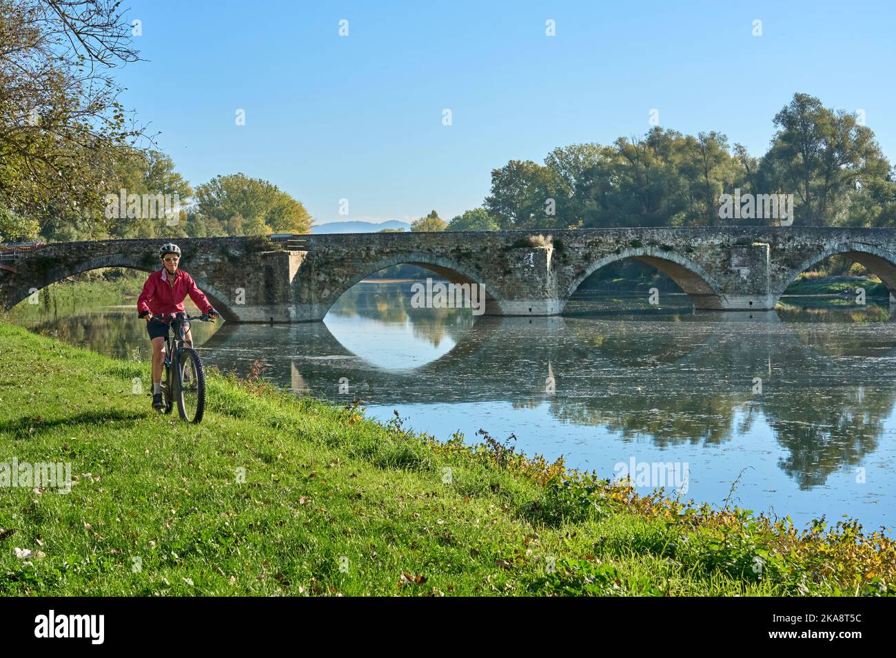 nice senior woman riding her electric mountain at river Arno near
