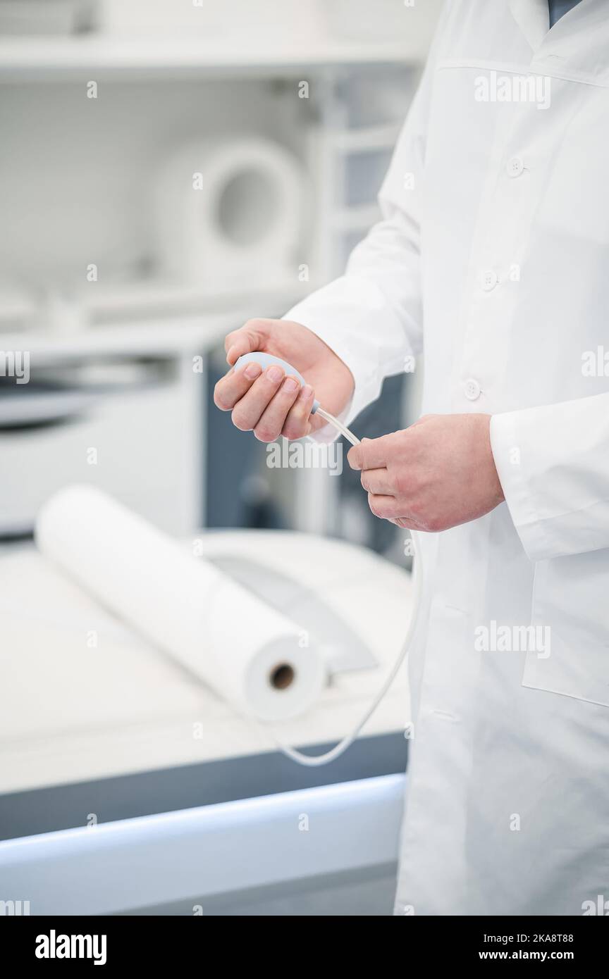 Male gray-haired doctor in a lab coat working in diagnostic center Stock Photo