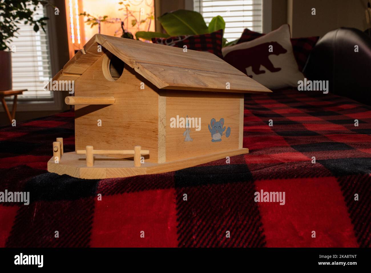 A birdhouse created from wood and decorated with a child's touch. Stock Photo