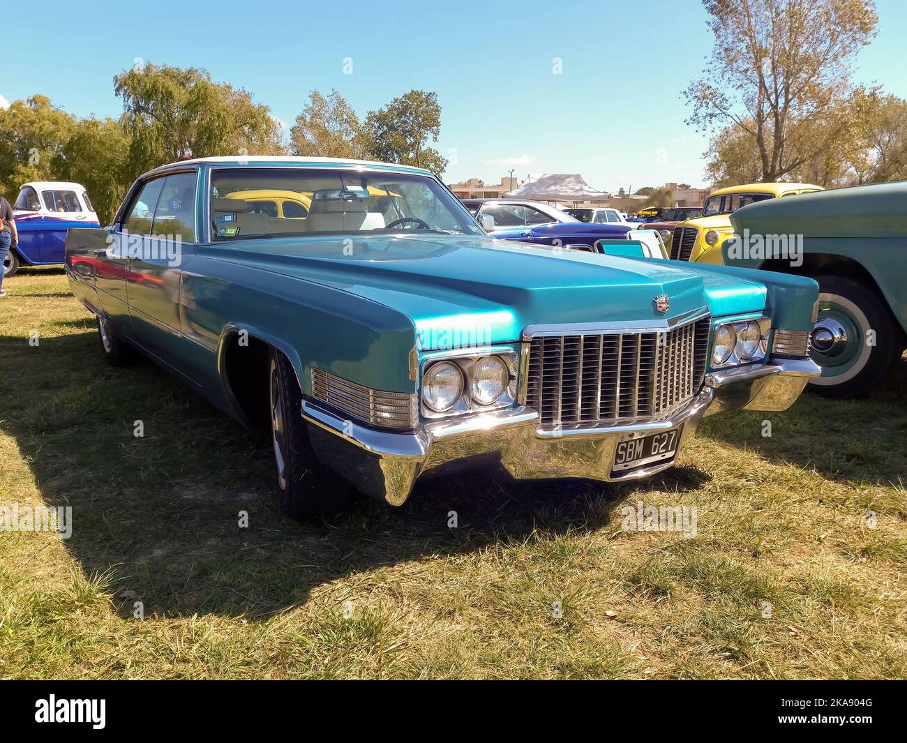 Chascomus, Argentina - Apr 9, 2022 - Old blue luxury Cadillac DeVille sedan four door 1970 in the countryside. Nature, grass, trees. Classic car show. Stock Photo