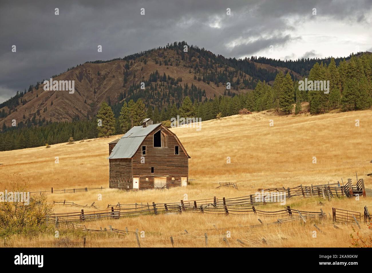 A long-abandoned barn on a hillside in National Forest land in central Washington State, on the eastern slope of the Cascade Range. Stock Photo